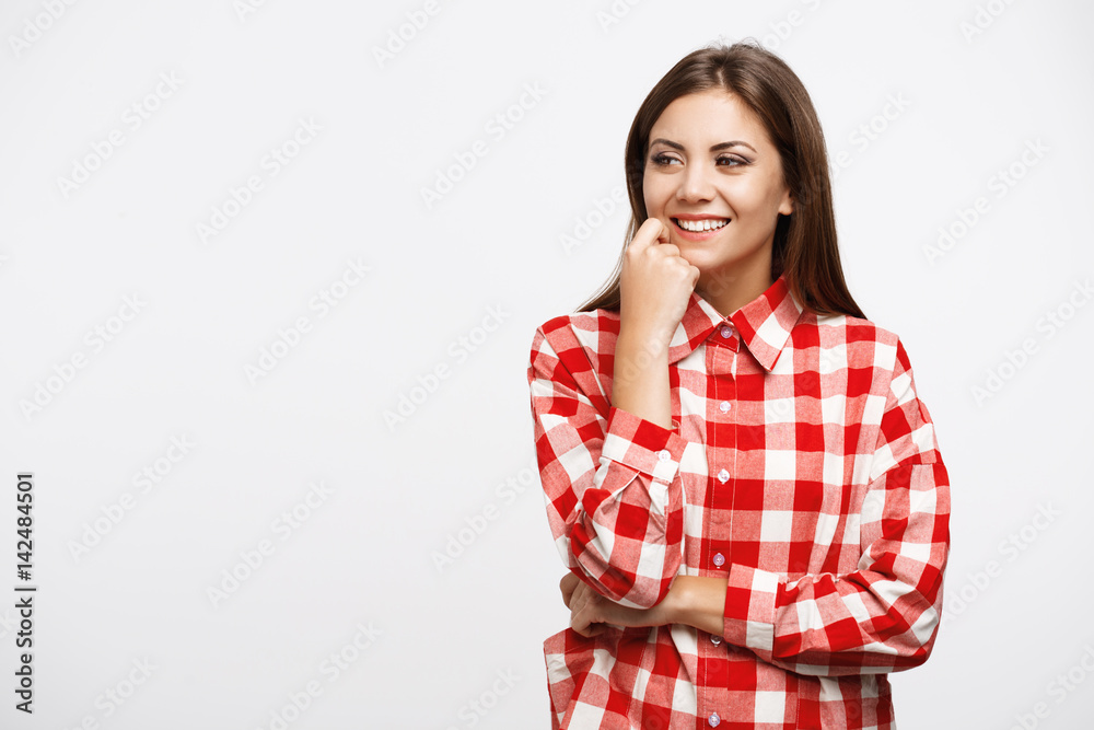 Girl in check shirt posing with right hand on cheek