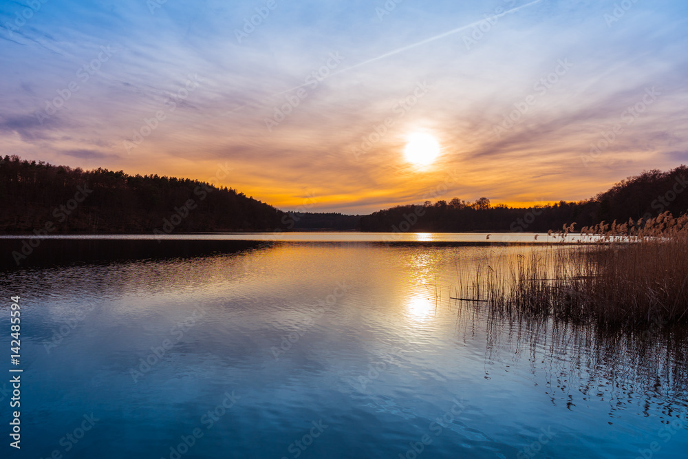 Scenic rural landscape of a sunset over a lake