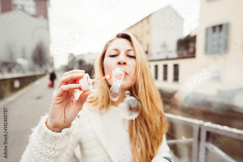 Young beautiful woman playing with bubble soap - happiness, cheerful, having fun concept