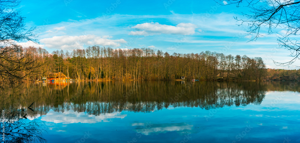 Panoramic view of a tranquil lake with reflections Panoramic view of a tranquil lake with reflections