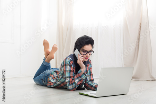 Young girl lying with a laptop.