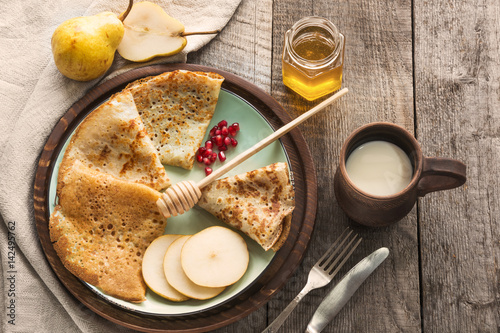 Photos Tasty traditional russian breakfast of slapjack with honey on plate