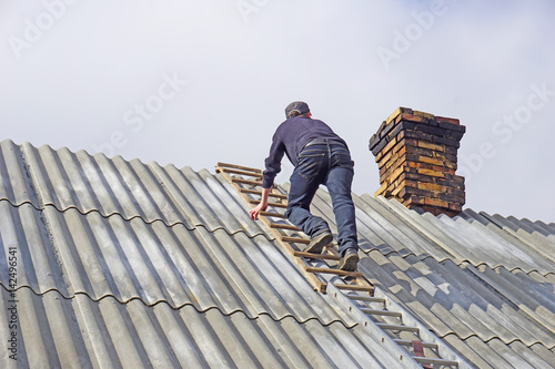 Man makes a masonry of bricks. Roof chimney repair