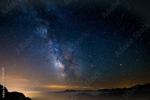 The outstanding beauty of the Milky Way arc and the starry sky reflected on lake at high altitude on the Alps. Fisheye scenic distortion and 180 degree view.