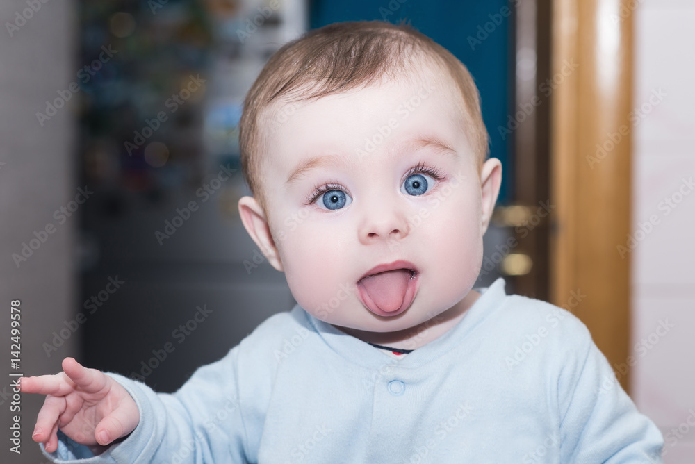 Funny child shows tongue and points fingers. Portrait of cute baby girl  with blue eyes Stock Photo | Adobe Stock