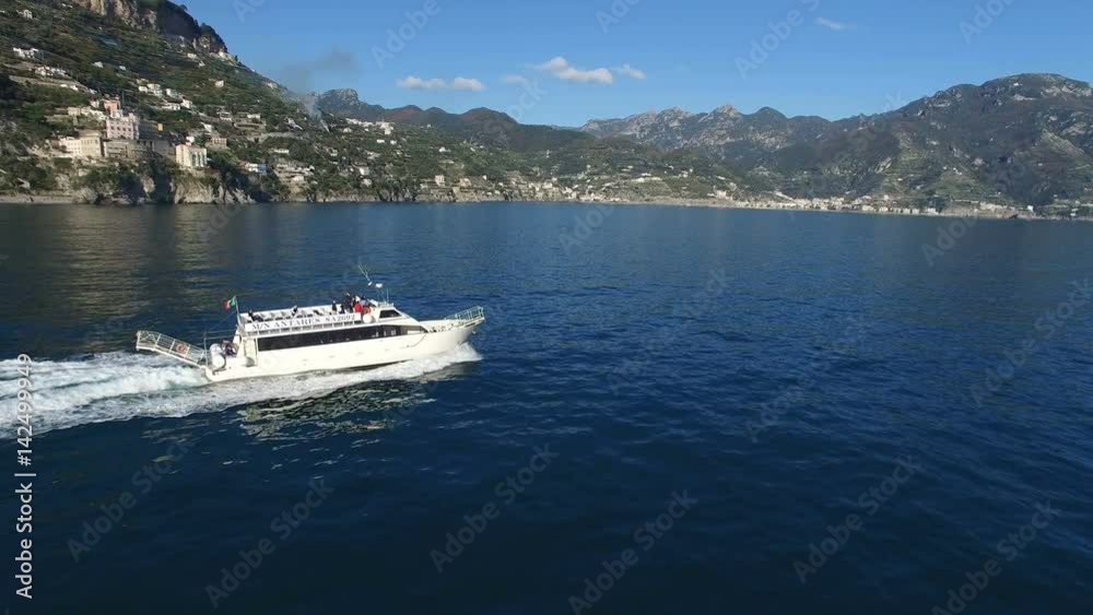Aerial view of a ferry transporting passengers navigating off the coast of Amalfi, Italy. Aerial view of a ferry transporting passengers navigating off the coast of Amalfi, Italy.