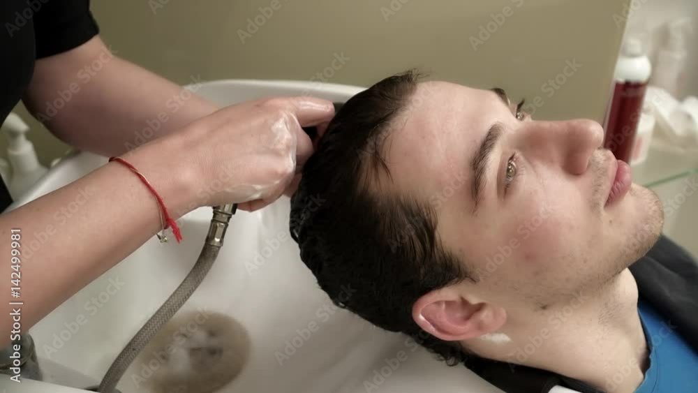 Hairdresser is washing man's hair in salon Hairdresser is washing man's hair in salon