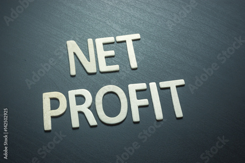 Net profit written with wooden letters on a green background