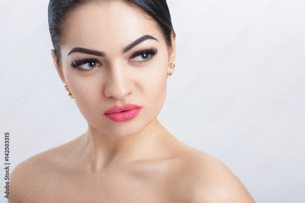 Front portrait of attractive young brunette woman on grey background. girl with clean skin Front portrait of attractive young brunette woman on grey background. girl with clean skin