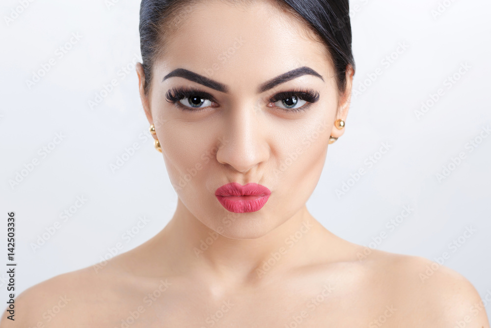 Front portrait of attractive young brunette woman on grey background. girl with clean skin Front portrait of attractive young brunette woman on grey background. girl with clean skin