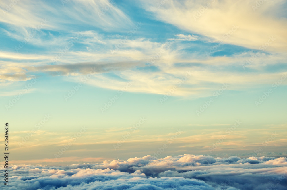 Gold and blue colors clouds abstract background. Sunset sky above the clouds. Universal background in soft pastel colors. Gold and blue colors clouds abstract background. Sunset sky above the clouds. Universal background in soft pastel colors.