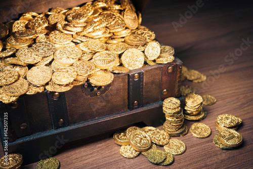 Open treasure chest with gold coins on a dark background