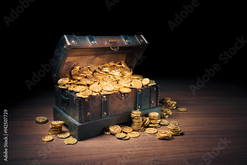 Open treasure chest with gold coins on a dark background