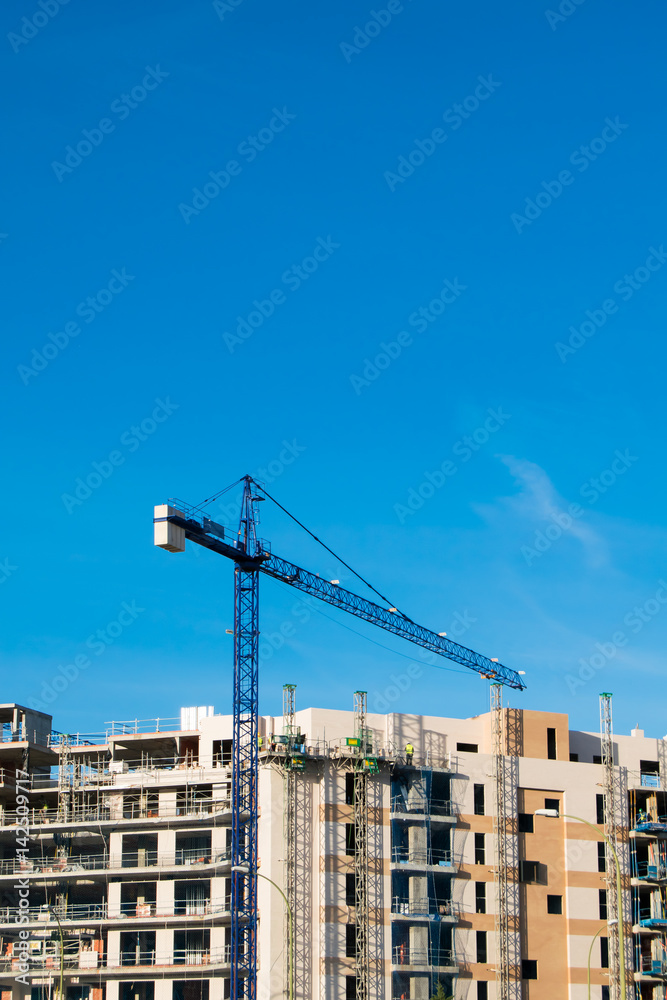 Crane, building and blue sky.