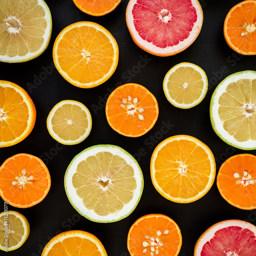 Lemon, orange, mandarin, grapefruit and sweetie on black background. Flat lay, top view. Fruit colorful background