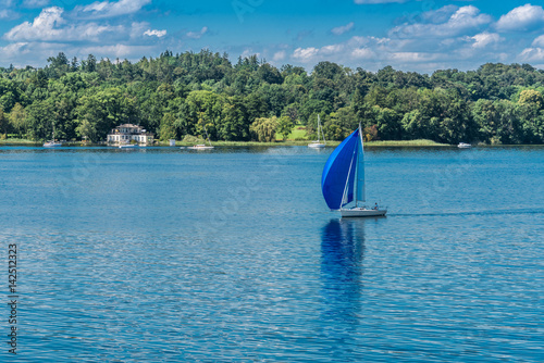 Blaue Segelyacht schippert über den Starnberger See in Bayern photo