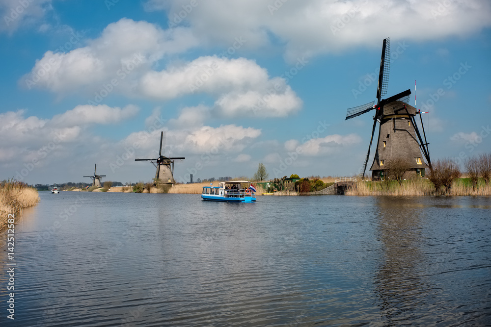 Windmills and boat in the Unesco site of Kinderdijk, the Netherlands.