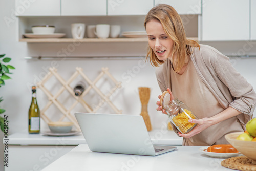 Cute woman learning from internet recipe of food preparation