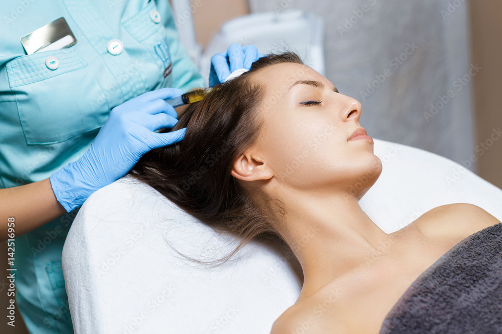 Needle mesotherapy. Cosmetic been injected in woman's head. Thrust to strengthen hair and their growth Needle mesotherapy. Cosmetic been injected in woman's head. Thrust to strengthen hair and their growth