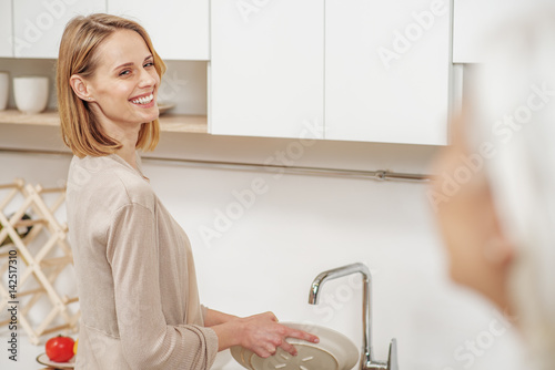 Fotografie Cheerful lady doing housework for loving parent