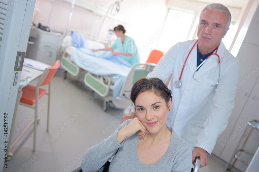 Obraz premium Doctor pushing patient in wheelchair