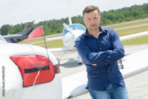 Portrait of man leaning on aircraft photo
