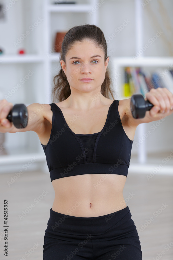 beautiful athletic woman pumping up muscules with dumbbells in gym beautiful athletic woman pumping up muscules with dumbbells in gym