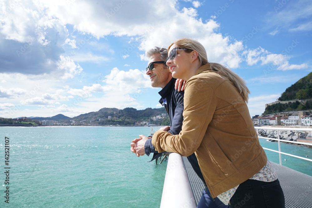 Fototapeta premium Para w średnim wieku obejmująca się nad morzem, San Sebastian