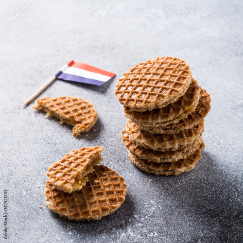 Mini stroopwafel, syrupwaffles cookies and Netherlands national flag light gray background with copy space. photo