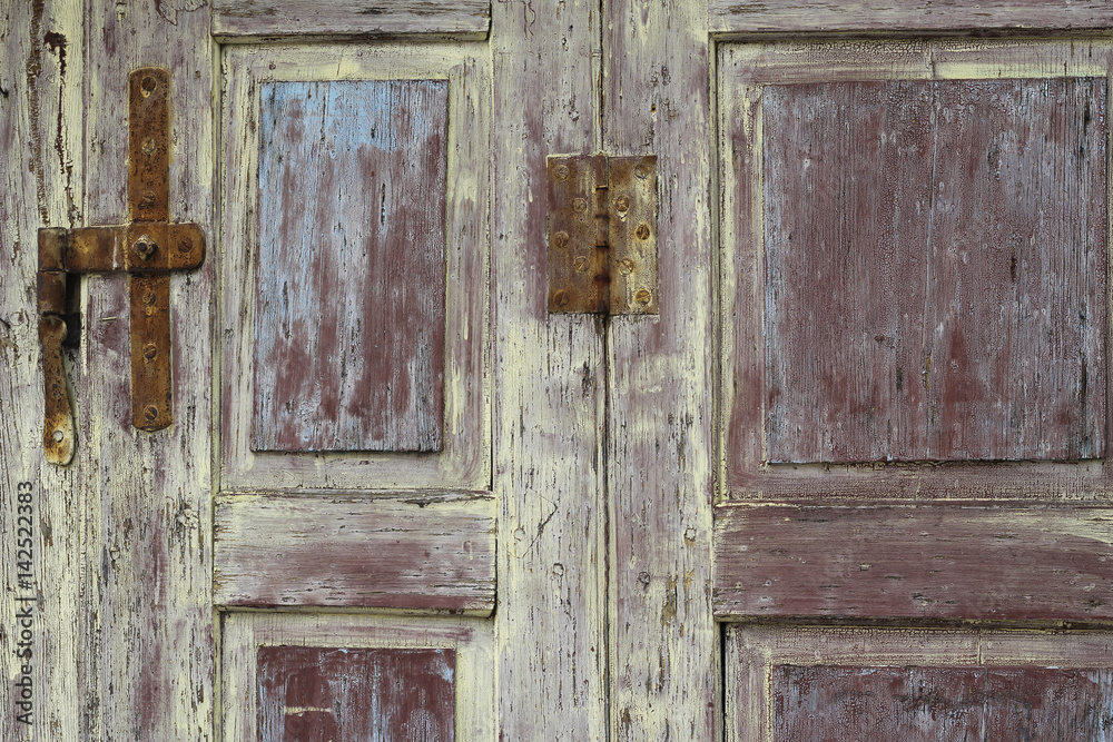 Red, yellow and blue coatings on a paling wooden door