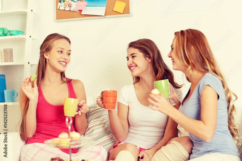 happy young women drinking tea with sweets at home happy young women drinking tea with sweets at home