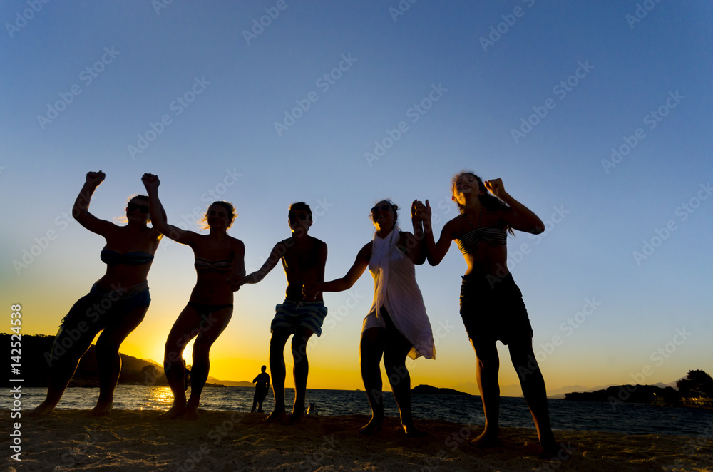 Silhouette of People Dancing On Beach at Sunset
