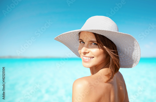 smiling young woman in sun hat on summer beach