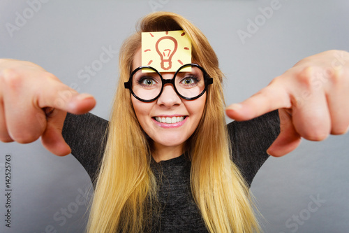 Woman having light bulb mark on forehead thinking photo