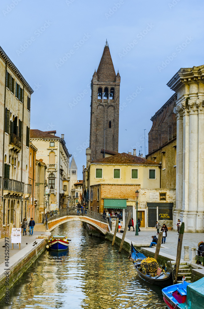 VENICE, ITALY - circa MARCH, 2016: Ancient church tower of Campo San Barnaba among chanal houses with traditional architecture for Venice