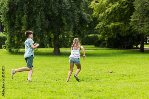 group of happy kids or friends playing outdoors