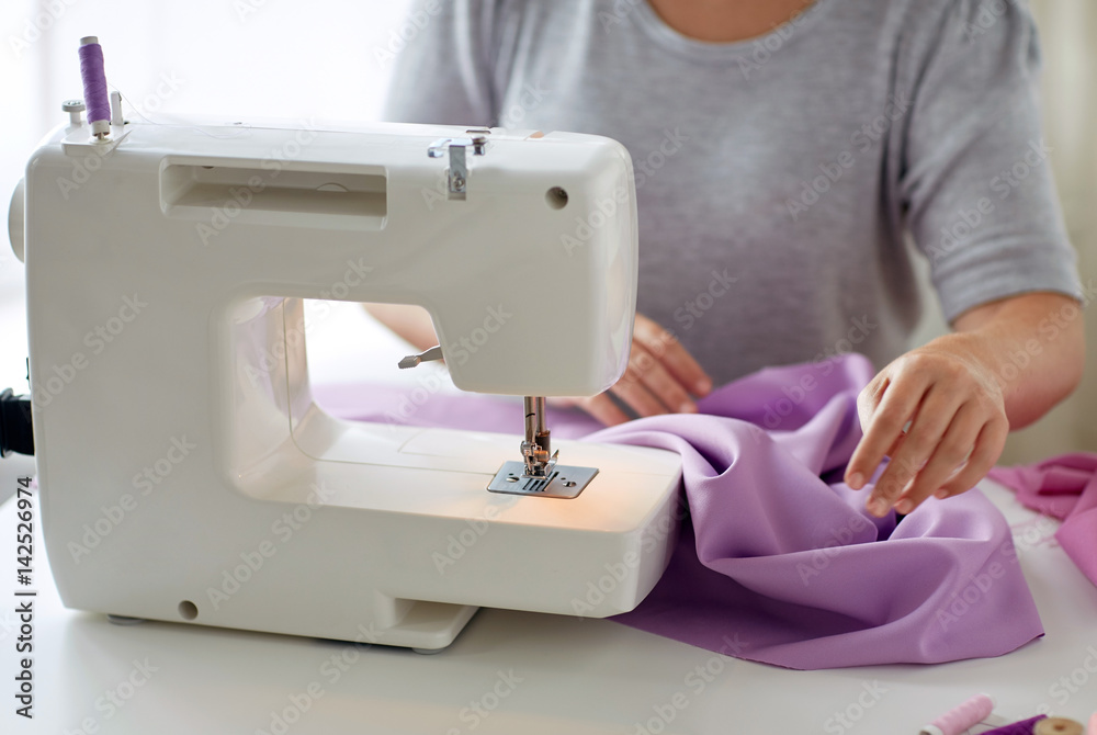 tailor woman with sewing machine stitching fabric