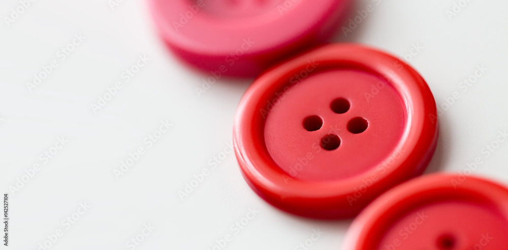 red and pink sewing buttons on white background red and pink sewing buttons on white background