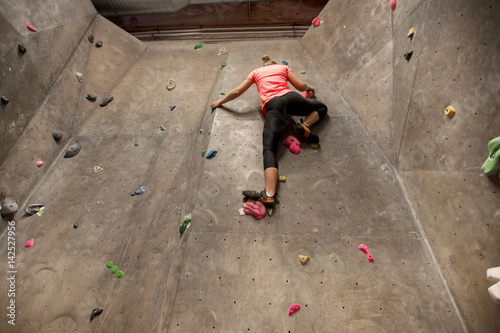 young woman exercising at indoor climbing gym