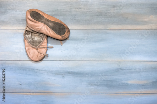 A pair of girl used shoes for dance, isolated on wooden background.