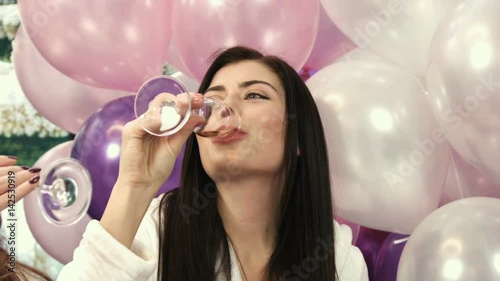 Close up attractive young woman drinking ghampagne from glasses at the party. photo