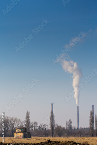Air pollution by smoke coming out of factory chimney