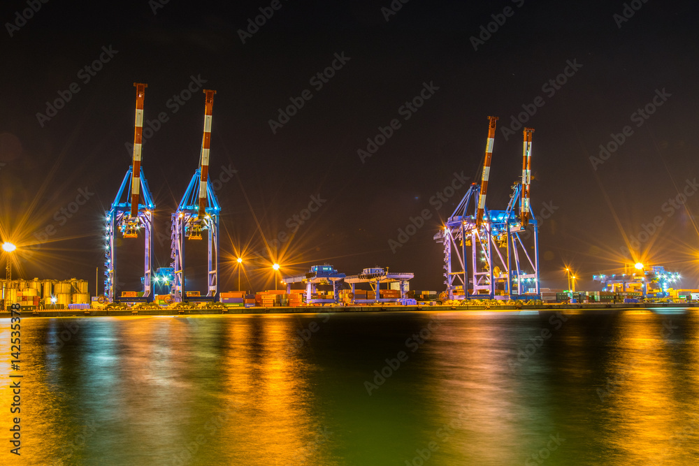 Φωτογραφία night view of industrial cranes in the port of genoa in Italy.