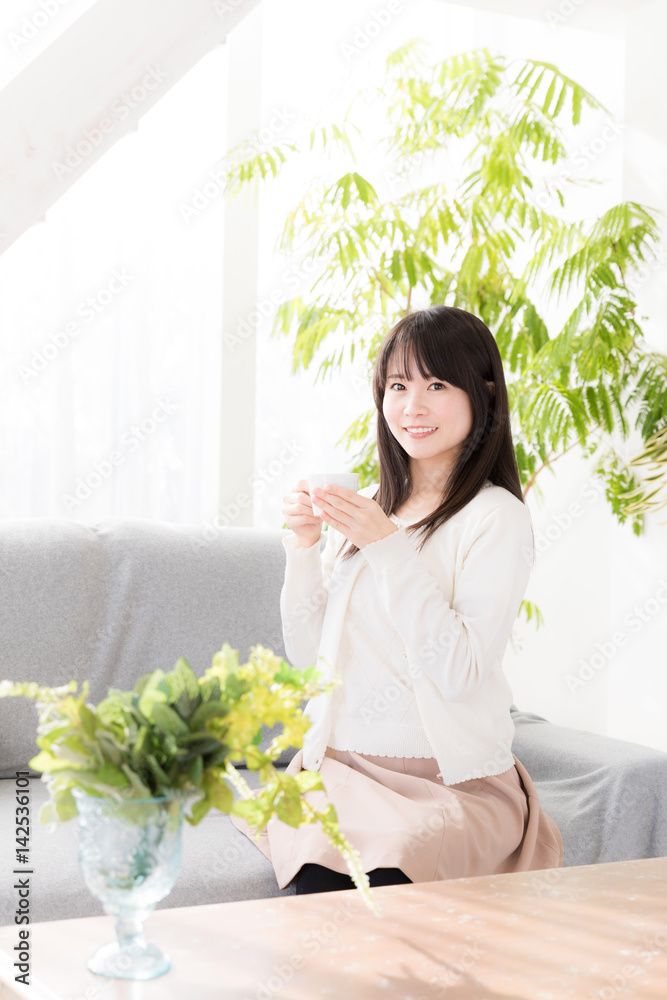 attractive asian woman relaxing in living room attractive asian woman relaxing in living room