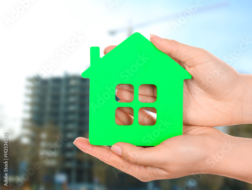 Female hands holding model of house isolated on white