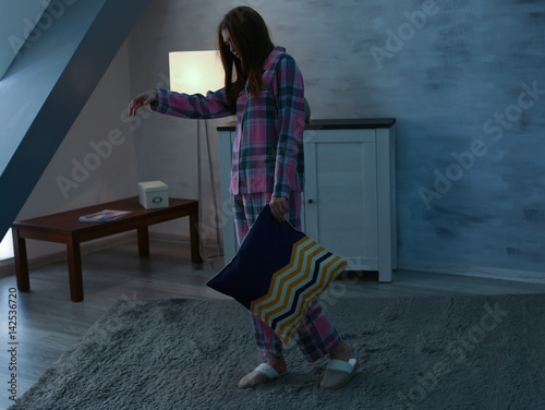 Young sleepy woman with pil...