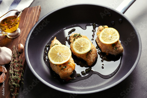 Delicious chicken breasts with lemon on kitchen table