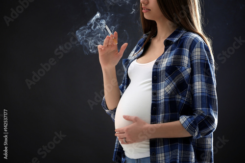 Pregnant woman smoking ciga...
