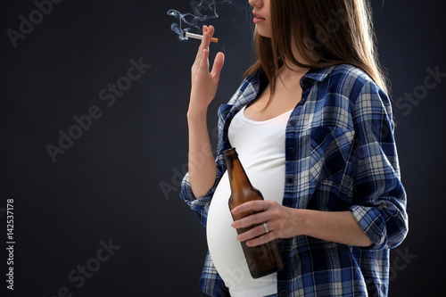 Pregnant woman smoking ciga...