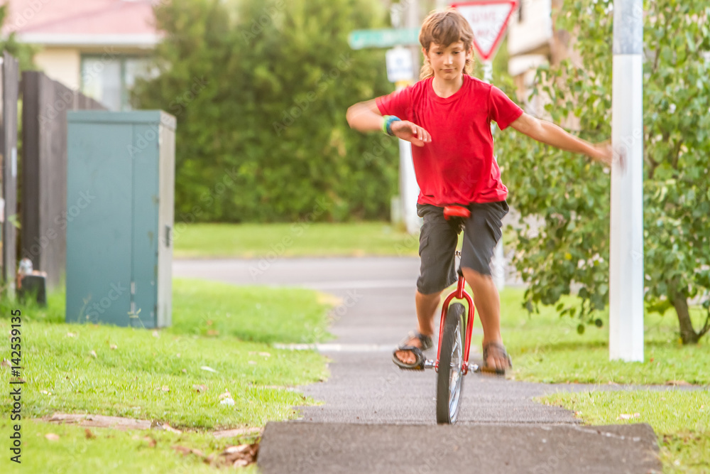 outdoor portrait of young boy riding a unicycle on natural background outdoor portrait of young boy riding a unicycle on natural background